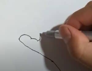 Drawing step-by-step heart illustration with pen on paper for beginner art tutorials.